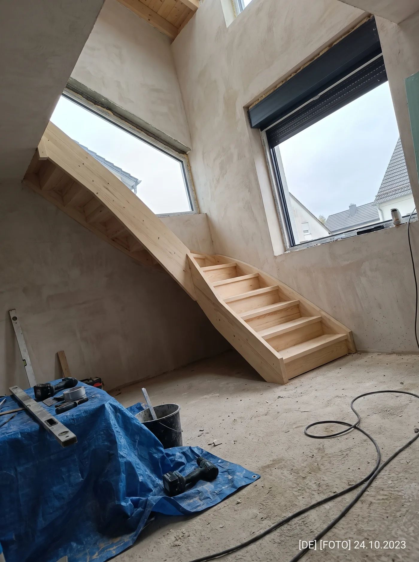 Handyfoto: fertige Treppe im Baustellenlicht, Werkzeug davor