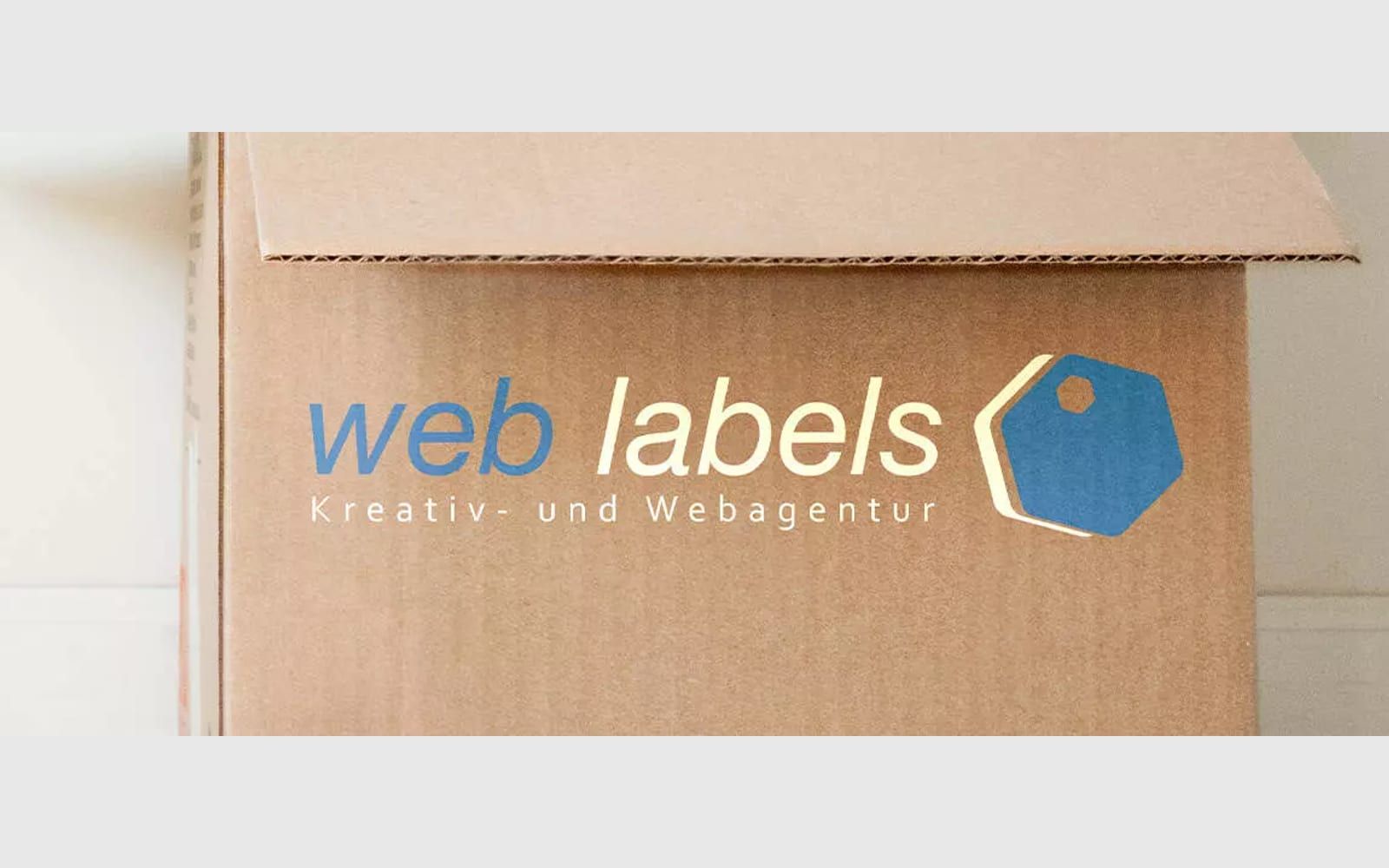 Beitragsbild: Umzugskarton mit Web-Labels-Logo zum Umzug nach Bargteheide